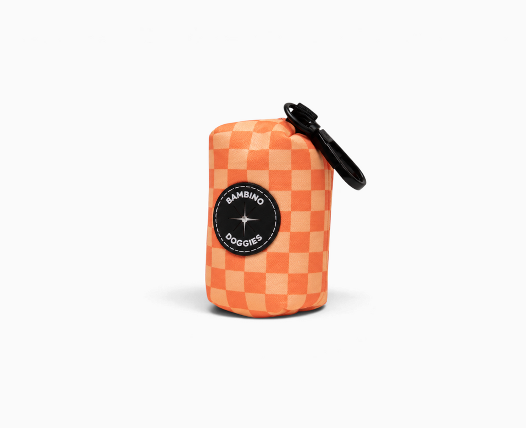 Portabolsas higiénica Bambino Doggies de neopreno naranja con estampado de cuadros y gancho metálico para correa